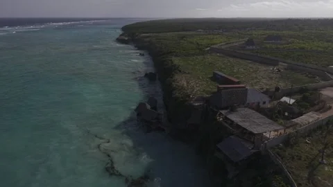 Drone lowers over water facing Usumba Rock restaurant at high tide Stock Footage 344111334