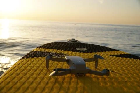 Drone lying on SUP board at sunset Stock Photos