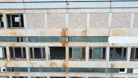 Drone makes an evening flight around abandoned factory with broken windows on Stock Footage 137698667