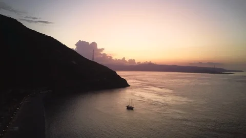 Drone makes an evening flight over the coast, there is a yacht in the sea. Stock Footage 124626982