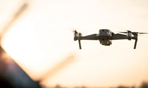 Drone like Mavic 2 Pro flying during sunset. Stock Photos