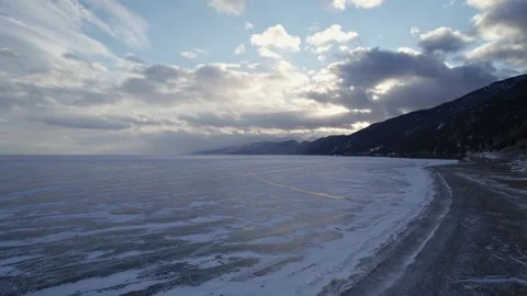 Drone move directly over the frozen lake Baikal to sunset Video stock 224329479