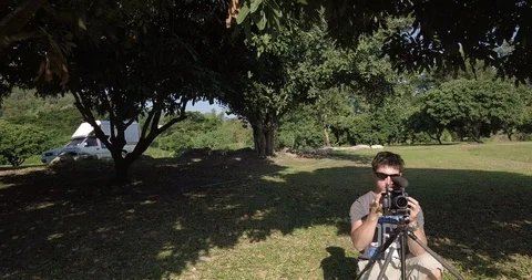 Drone move in shot with a man is taking video in park at Chiang Mai Thailand Stock Footage 100747079