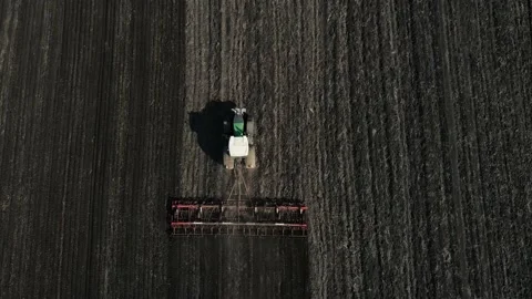 Drone movement over a large green tractor plowing the ground. aerial shooting Stock Footage 154627791