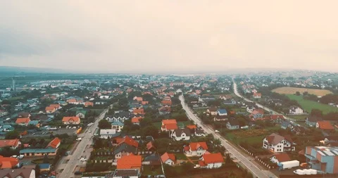 Drone moves along the street between houses with red roofs, the crossroads and Stock Footage 126935926
