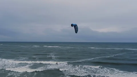 Drone moves backwards from a kiteboarder that surfs near Zandvoort Stock Footage 100766013