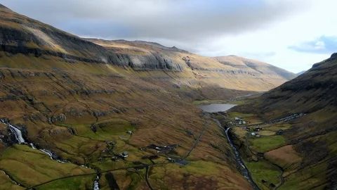 Drone Moves Forward Through Green Valley, Village Below, Streymoy Island, Faroe Stock Footage 112005259