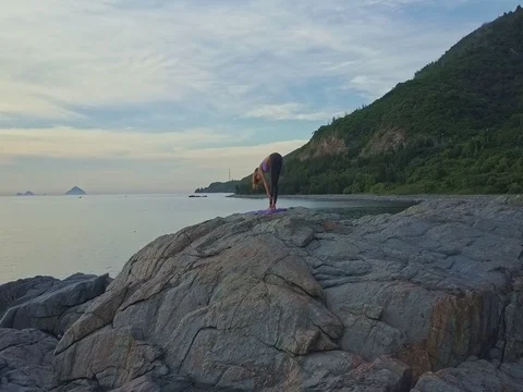 Drone Moves to Girl Standing in Yoga Pose against Ocean Sky Stock Footage