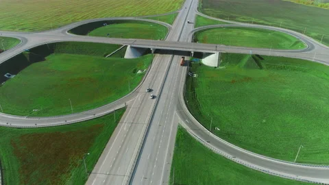 The drone moves over a traffic intersection. Trucks and cars drive along the Stock Footage 136557258