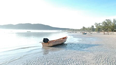 Drone moves right side, from starting view of boat and sea to beach Stock Footage 111333909