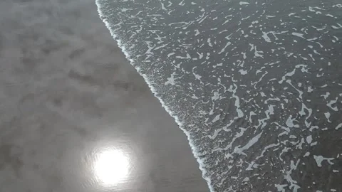 Drone moves slowly over perfect reflections on a beach with shallow water. Video stock 228628802