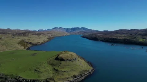 Drone moving backward over lake and green hills in Scotland 動画素材 334458115