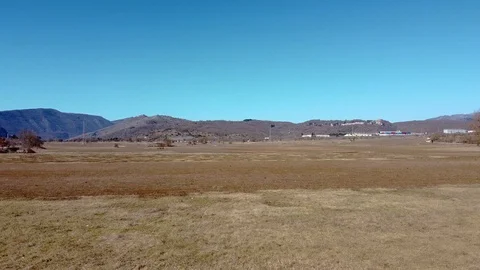 Drone moving backwards on an open field in the mountains Stock Footage 125100915