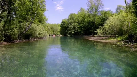 Drone moving close to a river with two canoes near to a forest Stock Footage 263889696