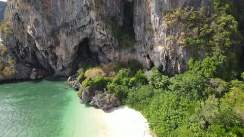 Drone moving closer to a cave at the beach Stock Footage 194385366