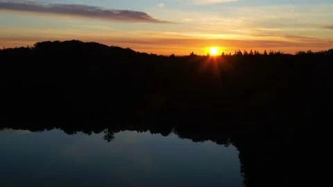 Drone moving down over forest lake in early sunrise 4K Stock Footage 236723451