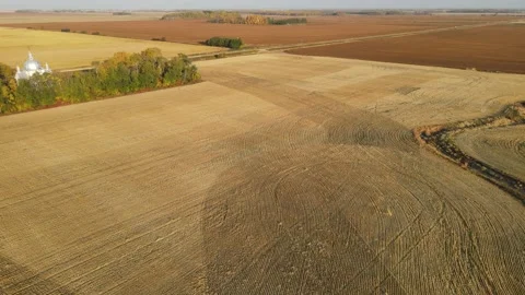 Drone moving forward and turning right over harvested farmland Stock Footage 219224942