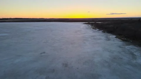 Drone moving forward over a lake just after the sun has set below the horizon.  Stock Footage 151905471