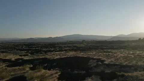Drone Moving Forward over Lava Rocks towards Sunset Stock Footage 139930903
