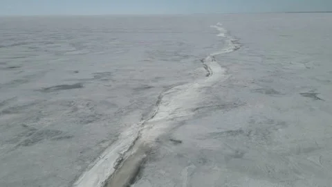 Drone moving forward over a vast frozen lake that is covered in snow, Stock Footage 246946446
