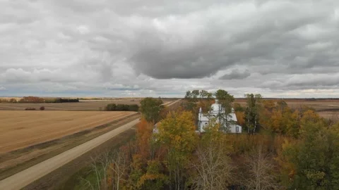 Drone moving forward at tree top elevation over a churchyard  Stock Footage 142318739
