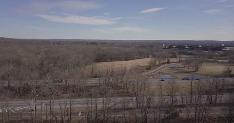 Drone moving left to right over highway winter trees sunny 스톡 동영상 101125392