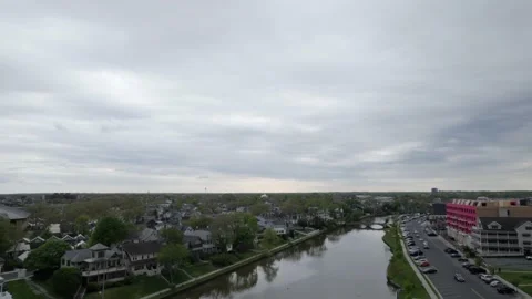 Drone moving over beach town hotels and small river Stock Footage 160071894