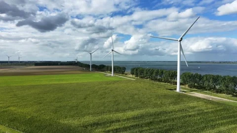 Drone moving over green fields towards wind turbines blue sky 스톡 동영상 343244755