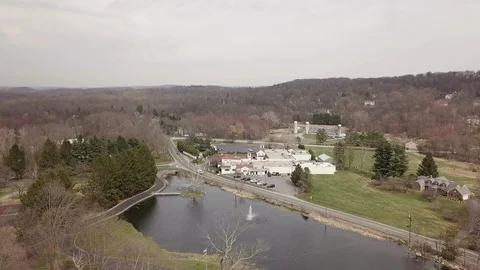 Drone moving over small lake towards building 動画素材 106664080