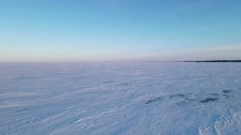 Drone moving quickly low above a frozen lake with blue colored snow Vídeo Stock 228865907