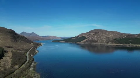 Drone moving right above lake and mountain landscape in Scotland 動画素材 334458544