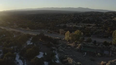 Drone moving right following a remote snowy road at sunrise in the desert Stock-Footage 167671716