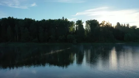 Drone moving sideway above calm river surface Stockbeeldmateriaal 320117667