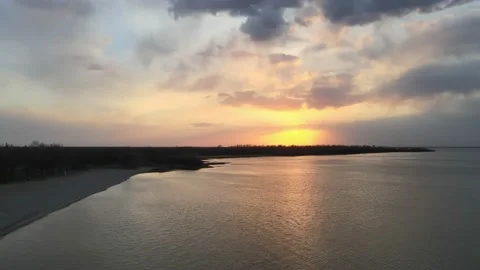 Drone moving sideways above a large lake at sunset looking at a sky  Stock Footage 229801026