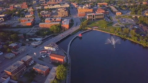 Drone moving sideways and round over a small town, by the water, with Stock Footage 102903321