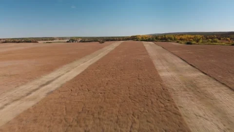Drone moving slowly above a partially harvested field of canola  Stock Footage 140121761