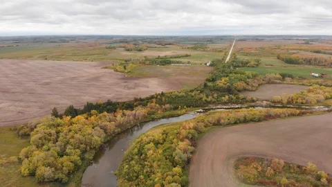 Drone moving slowly forwards to show a vast farm, forest and river landscape  Stock Footage 117859980
