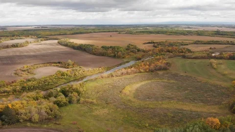 Drone moving slowly forwards to show a vast farm, forest and river landscape Stock Footage 117866461
