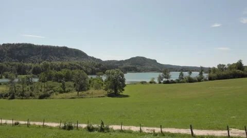 Drone moving towards a lake in the summer with mountains and trees Stock Footage 149307799