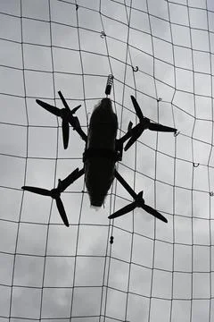 Drone with munitions got caught behind the anti-drone net. Stock Photos