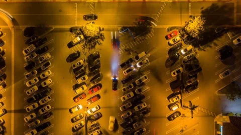 Drone night hyperlapse of busy parking lot at night as camera pans Stock Footage 87903522
