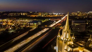 Drone nightlapse pens down showing freeway, shopping plaza, and church 库存影片 85643535