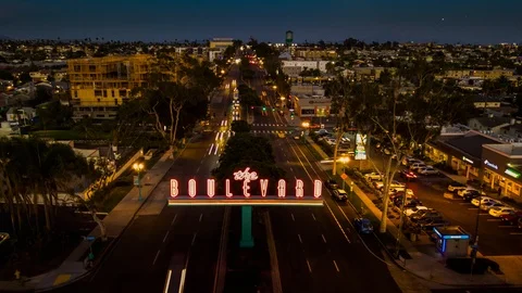 Drone Nightlapse of traffic passing under famous vintage neon BOULEVARD sign. 库存影片 95558631