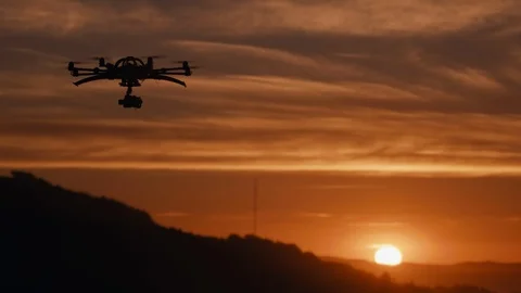 Drone octocopter flying at sunset with small camera over countryside Stock Footage 91375146