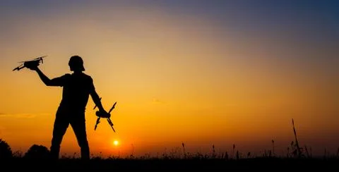 Drone Operator with Aircrafts in Hands Preparing For Scenic Sunset Flight.  Stock Photos