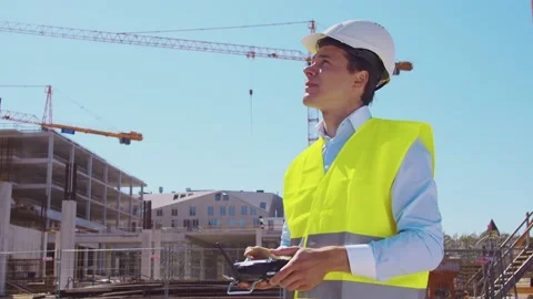 Drone operator holding remote controller. Professional builder in helmet and Stock Footage 137666734