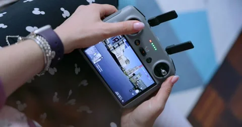 Drone Operator Holding Remote Controller With Live Aerial City View On Built-In Stock Footage 336657862