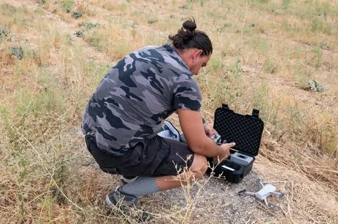 Drone operator preparing his drone for flight in a field Stock Photos