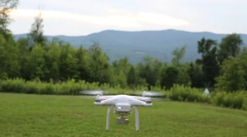 A drone or quadcopter hovering and taking off in a backyard surrounded by Stock Footage 65497244