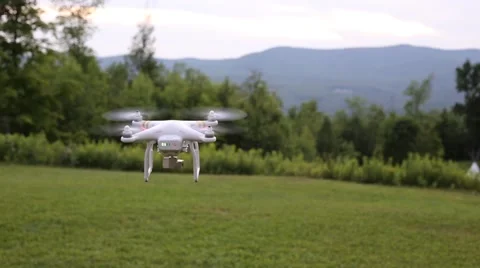 A drone or quadcopter hovering and taking off in a backyard surrounded by Stock Footage 65497277
